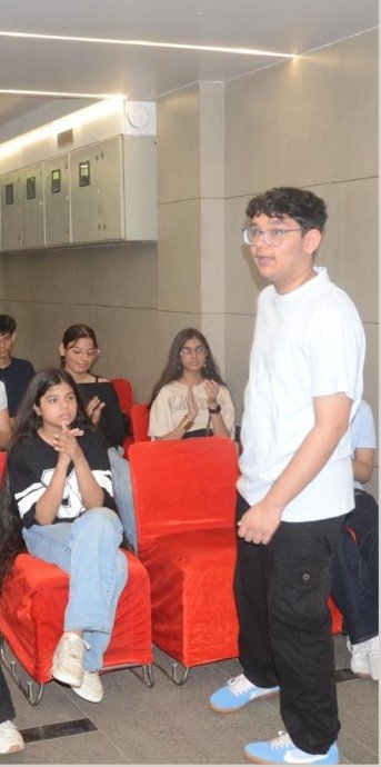 A Digital Decoded presenter speaking to a seated audience during a school masterclass